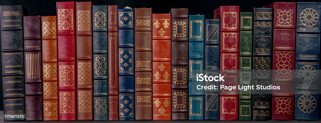 A stack of leather bound books with gold decoration A stack of beautiful leather bound books with golden decoration against a black background. Book Stock Photo