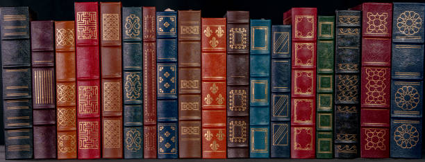 a stack of leather bound books with gold decoration - book book spine in a row library imagens e fotografias de stock