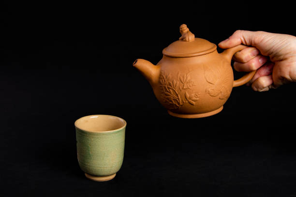 istock A tea pot ready to pour tea into a tea cup 1173671272