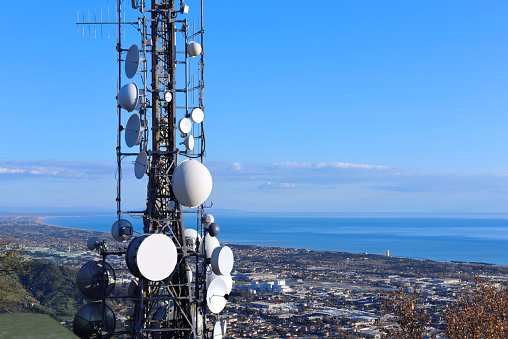 Vista aérea de una torre de telecomunicaciones, antena parabólica, repetidores de red, transceptor de base. Antena para red inalámbrica. Estación celular para la ciudad inteligente conectar y la costa como fondo. photo