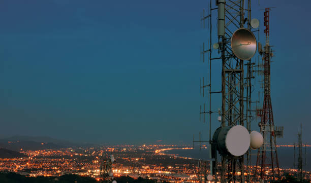 istock Telecommunications tower, antenna and satellite dish and coastline at night as background. Cellular station for smart city connect, aerial view. Copy space. 1173675103
