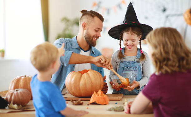 joyeux halloween! père de mère de famille et enfants ont coupé la citrouille pour des vacances à la maison - spider mum photos et images de collection