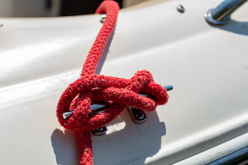 Close-up shot of knot tied to boat on pier in harbor