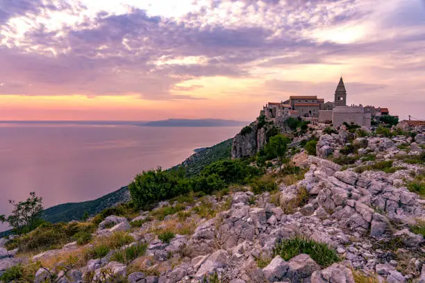 The famoud Lubenice village at sunset over the sea in Cres island Croatia .