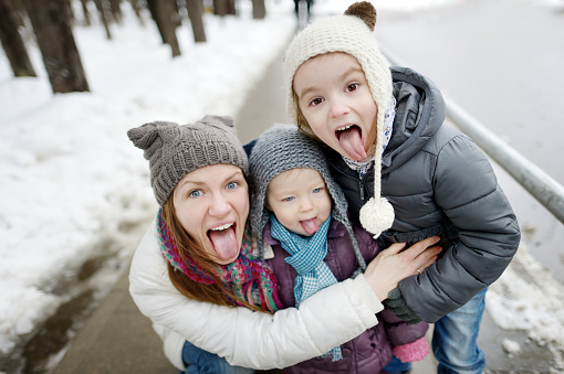 Happy mother and daughters having fun on winter