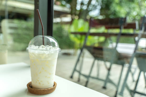 istock Cool milk in the plastic glass on the white table. 1173695527