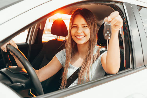 Young happy woman showing the key of new car Young happy woman showing the key of new car car key photos stock pictures, royalty-free photos & images