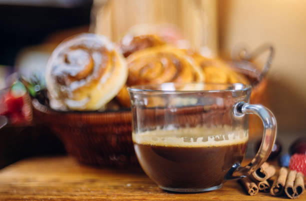 Cinnamon rolls with coffee on wooden table soft focus