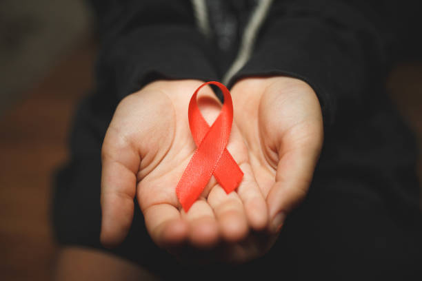 istock child with AID red ribbon on a dark background 1173706564