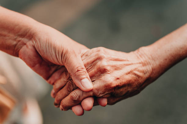 istock Helping hands elderly , care for the elderly concept.Old and young holding hands on light background. 1173708605