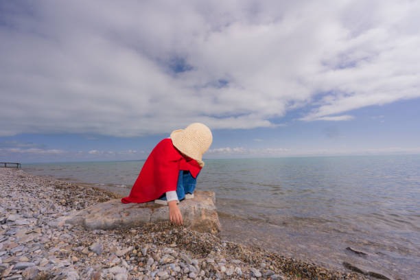 a young girl playing by the lake side