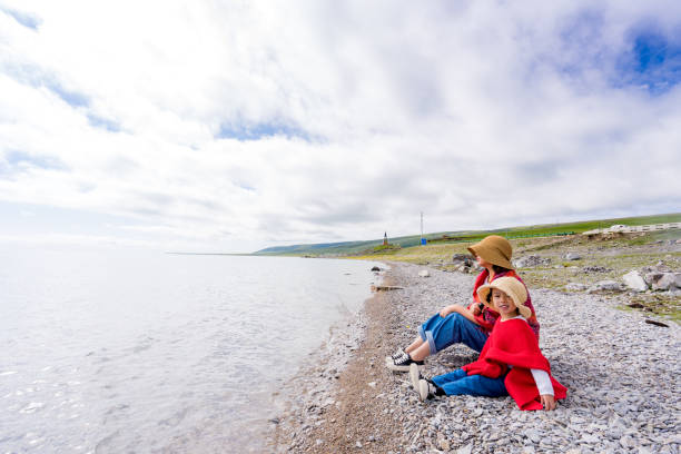 istock mother and daughter sitting by the lake side 1173718093