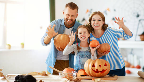 joyeux halloween! père de famille mère et fille d'enfant ont coupé la citrouille pour des vacances à la maison. - spider mum photos et images de collection