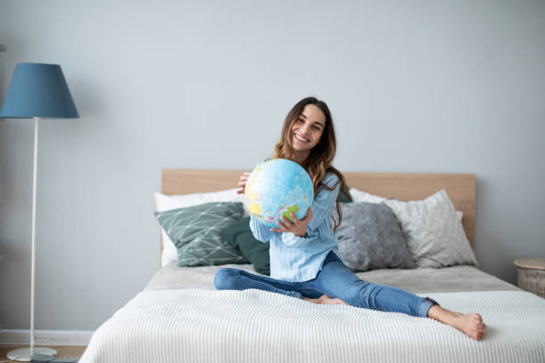 istock Happy woman holding a globe, indoor. 1173721290