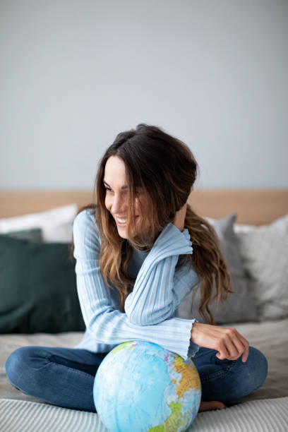 istock Happy smiling woman with a globe on bed. 1173721376