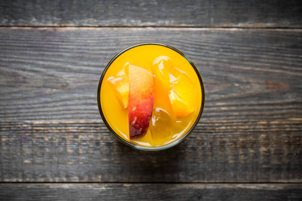 Fresh peach beverage in old fashioned glass on the rustic background. Selective focus.