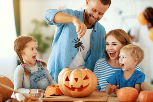 joyeux halloween! père de famille mère et enfants coupé citrouille pour des vacances à la maison. - spider mum photos et images de collection
