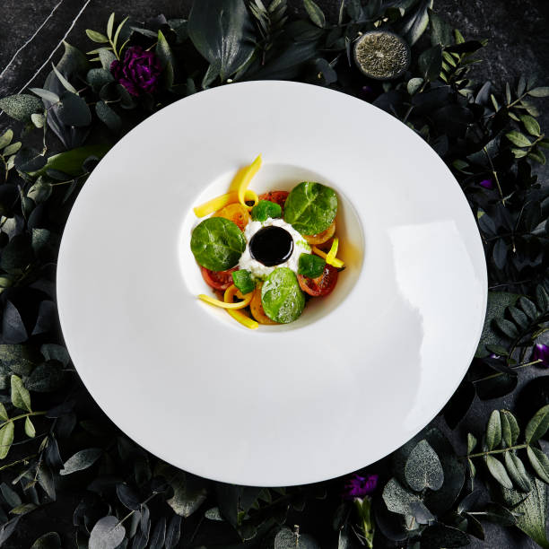 istock Stracciatella Di Bufala with Pickled in Olive Oil Tomatoes, Basil Marmalade and Cream. Exquisite Serving Restaurant Plate of Italian Pasta Filata Cheese Top View on Dark Leaves and Flowers Background 1173727913