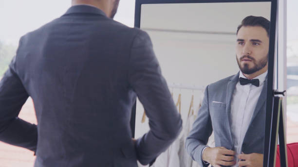 istock Man in formal suit getting dressed in dressing room for work or wedding. 1173730592