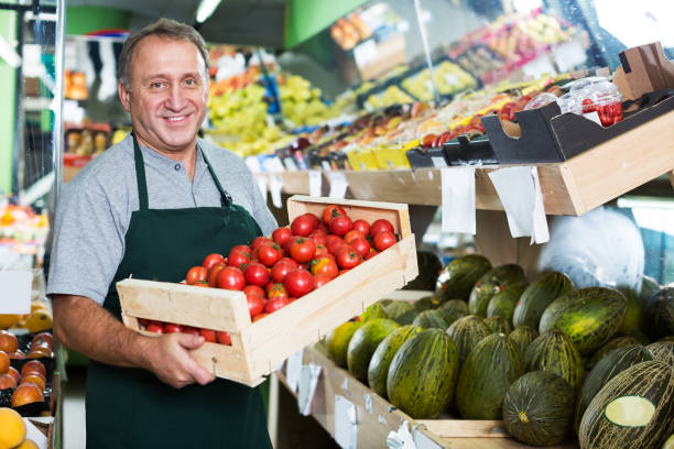 istock Man seller demonstraiting red tomatos 1173731465