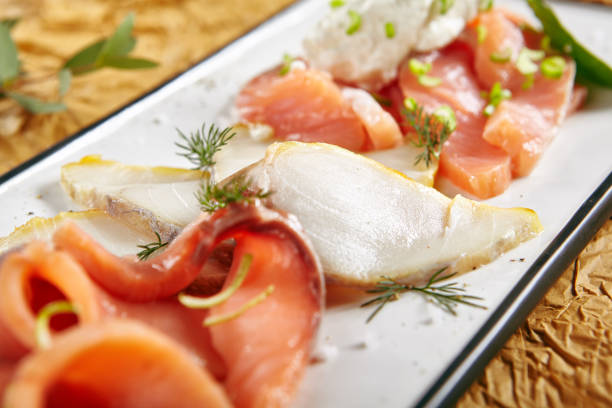 Exquisite Serving Restaurant Plate of Smoked Salted Raw White Fish Fillet with Red Fish Sashimi. Delicacy Fresh Seafood Dish with Toothfish, Salmon and Tuna Meat on Rustic Background Close Up