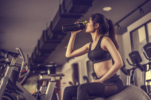 young fitness woman tired in gym drink   protein shake.exercising concept.fitness and healthy lifestyle - body building milk shake protein drink drink imagens e fotografias de stock