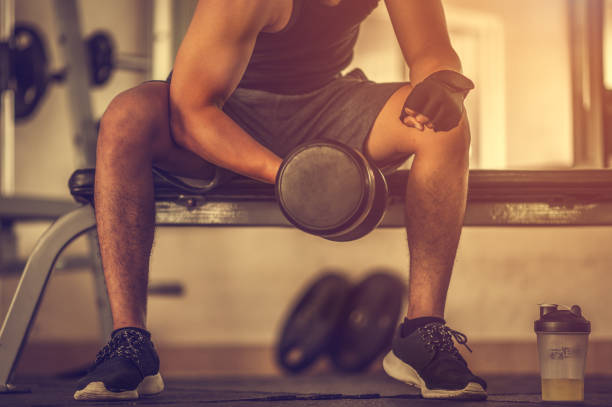 istock Bodybuilder working out with dumbbell weights at the gym.man bodybuilder doing exercises with dumbbell. Fitness muscular body 1173736340