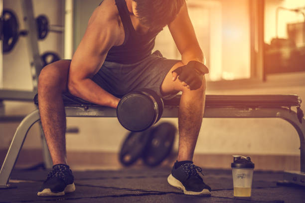 culturista haciendo ejercicio con pesas de mancuerna en el gym.man culturista haciendo ejercicios con mancuerna. cuerpo musculoso de fitness - muscular build fotos fotografías e imágenes de stock