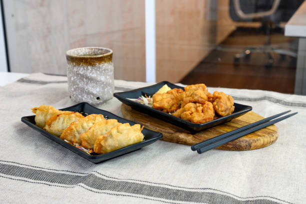 istock Karaage chicken deep fried with Gyoza dumplings and hot tea on cloth 1173736537