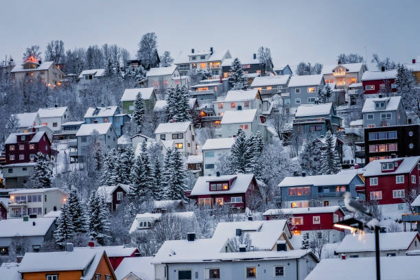Residential hillside houses in Tromso suburb covered in a deep snow in winter, northern Norway