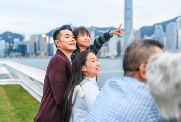 istock Young Chinese Boy Pointing at View from Ocean Terminal Deck 1173739167