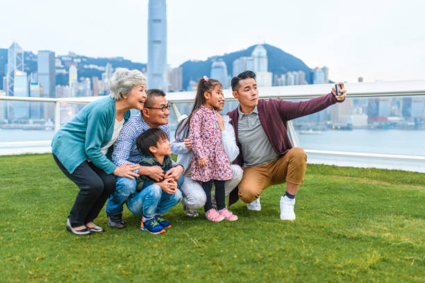 chinese family grouped for selfie at ocean terminal deck - harbour city imagens e fotografias de stock