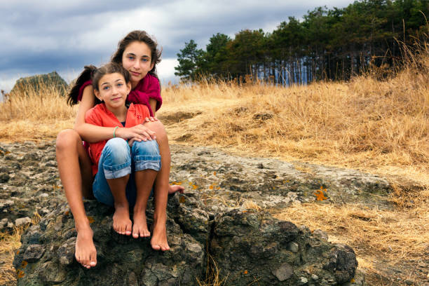 Two young girls hugging each other in the nature