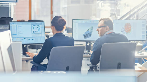 istock Back View of Team of Technology Engineers Working on Desktop Computers in Office. Screens Show IDE / CAD Software, Implementation of Machine Learning, Neural Networking and Cloud Computing 1173740441