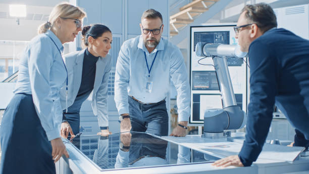 istock Team Meeting of Renewable Energy Engineers Working on an Innovative More Efficient Solar Panel Battery Concept. Group of Specialists Gathered Around Table, Solving Problems. Bright Research Facility 1173740572