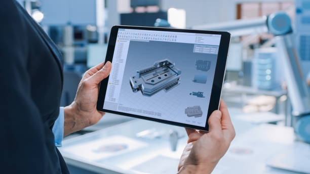 istock Stylish Female Industrial Robotics Engineer Uses Tablet Computer with CAD Software and to Manipulate and Program Robot Arm for Lifting, Moving Objects Technology Research Facility for Machine Learning 1173740582