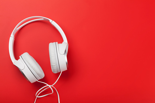 Music headphones on red background. Sound concept. Top view with copy space. Flat lay
