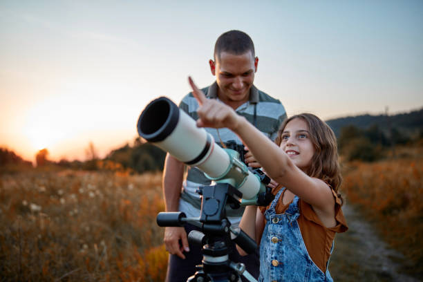 père et descendant observant le ciel avec un télescope. - astronomie photos et images de collection