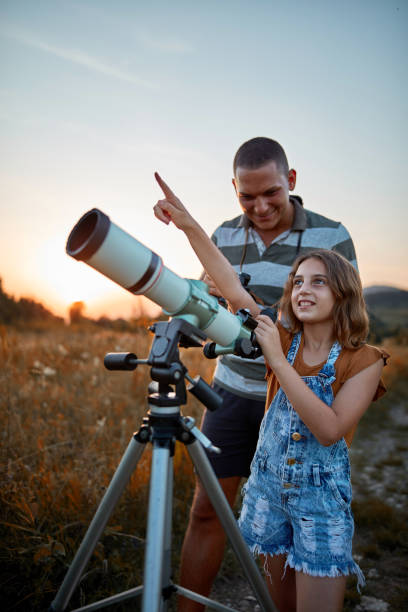 istock Father and daughter observing the sky with a telescope. 1173741540