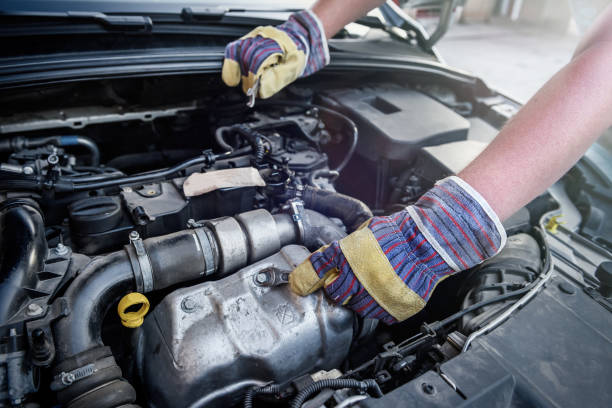 istock Human hands with wrenches in protective gloves upon car engine 1173741695