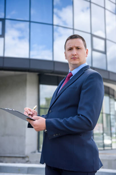 istock Smiling man in suit posing before business center 1173742539