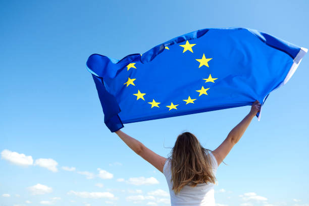 donna che sventola la bandiera dell'unione europea - flag european union flag european community european culture foto e immagini stock