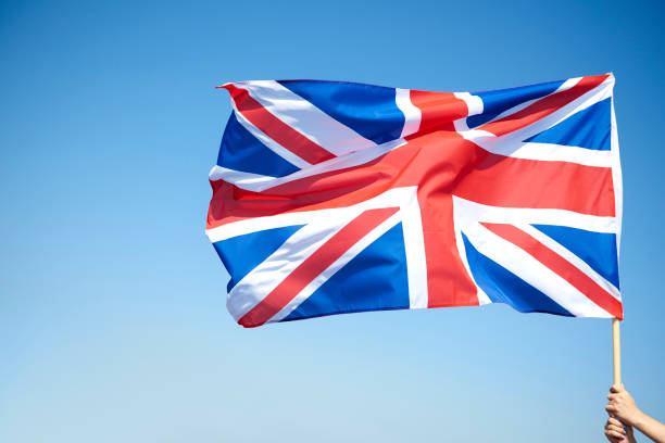 istock Woman’s hand holding British flag 1173744438