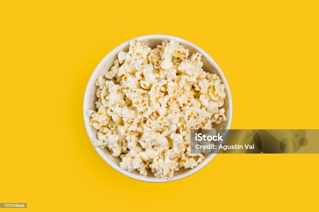 Popcorn in a white bowl Popcorn in a white bowl on a yellow background Popcorn Stock Photo