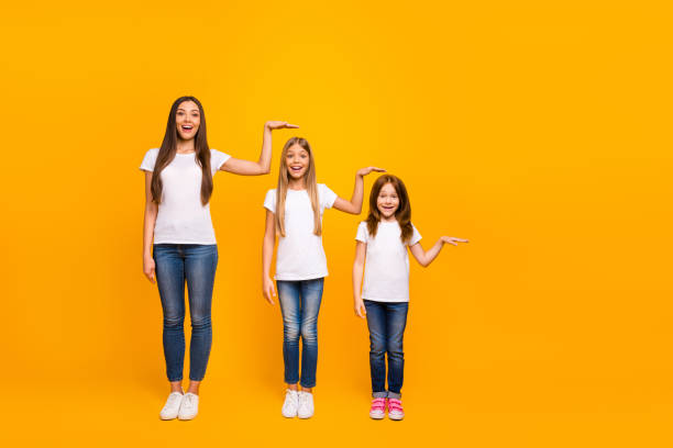 foto em tamanho completo de três irmãs irmã não acreditam que tal rápido crescimento até desgaste casual roupa isolada fundo amarelo - tall - fotografias e filmes do acervo