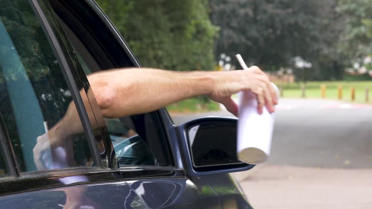 Litter being discarded from a car window.