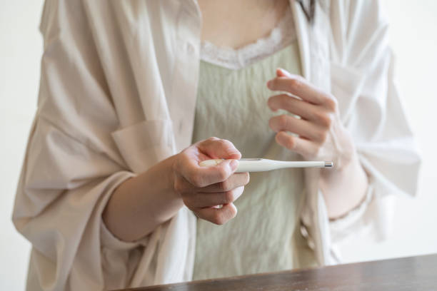 istock A woman measuring heat with a thermometer 1173752502