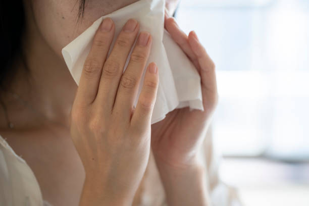 mano de mujer soplando la nariz con tejido - sneezing tissue young adult cold fotografías e imágenes de stock