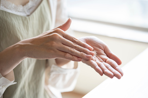 Manos de mujer aplicando crema de manos photo