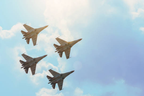 groupe de quatre avions de chasse avion de chasse soleil lueur de nuages dégradés toniques ciel. - defense industry photos et images de collection